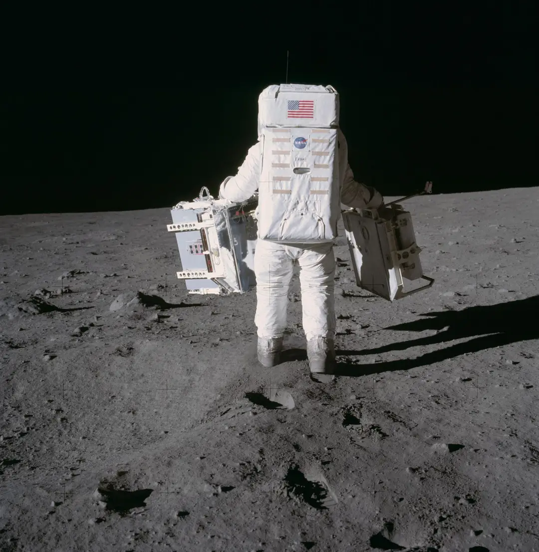 Astronaut membawa dua paket instrumen di permukaan Bulan